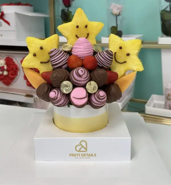 Pink fruit bouquet with chocolate-covered strawberries, smiling pineapple stars, and gold details — handmade birthday gift by Frutidetails Miami.