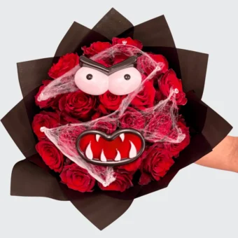 Halloween bouquet made with red roses arranged in a monster face design, decorated with spider webs — handcrafted by Frutidetails Miami.