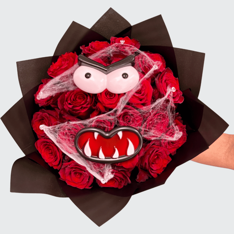 Halloween bouquet made with red roses arranged in a monster face design, decorated with spider webs — handcrafted by Frutidetails Miami.