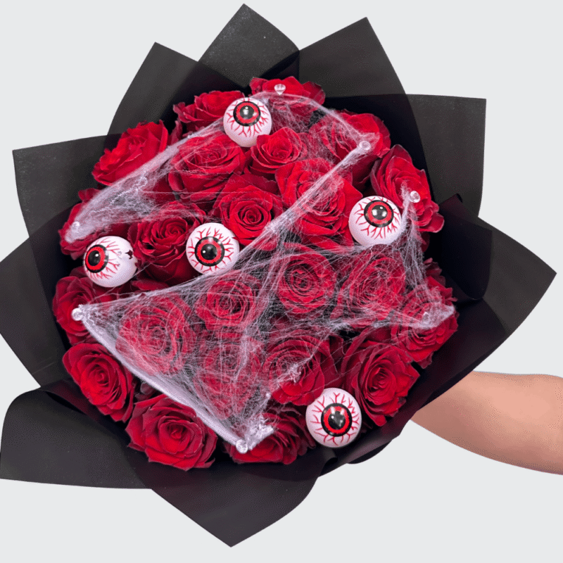 Halloween bouquet of red roses with eyeball decorations and spider web details β handcrafted spooky floral arrangement by Frutidetails Miami.